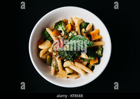 Une assiette de penne aux tomates fraîches, basilic, le brocoli à l'huile d'olive et parmesan Banque D'Images