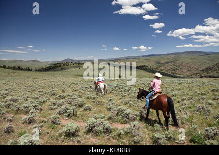 Usa, Wyoming, du cantonnement, un cowboy et cowgirl ride à travers un paysage sans fin, abara ranch Banque D'Images