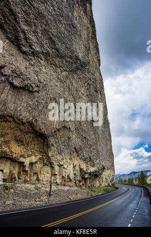 L'autoroute en dessous d'un immense mur de pierre le parc national de Yellowstone, Wyoming, USA Banque D'Images