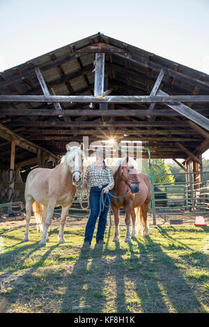 Usa, Ohio, Willamette Valley, claire carver se distingue avec ses chevaux en face de la grange à grande table Farms Winery, Gaston Banque D'Images