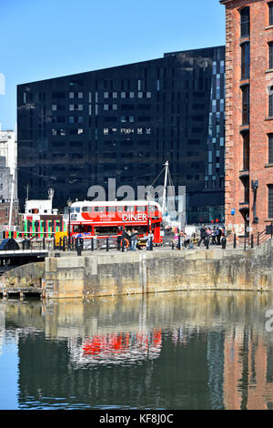 Réflexions à Liverpool Albert Dock de bus Routemaster rouge transformée en café diner viennent de restaurant dans la zone touristique animée dans le Merseyside UK Banque D'Images