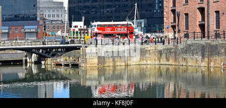 Réflexions à Liverpool Albert Dock de bus Routemaster rouge transformée en café diner viennent de restaurant dans la zone touristique animée dans le Merseyside UK Banque D'Images