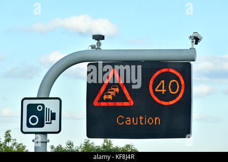 Seul panneau autoroute M25 signe au-dessus d'une voie seulement, limite de vitesse variable et du court message d'avertissement avec des caméras de vidéosurveillance complète et signe de caméra standard UK Banque D'Images