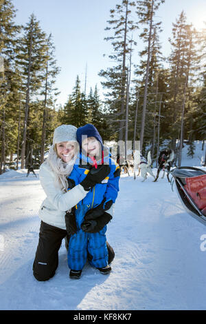 Usa (Oregon, bend, une maman et son fils sourire pour une photo avant de partir pour leur trajet en traîneaux à chiens à mt bachelor. Banque D'Images