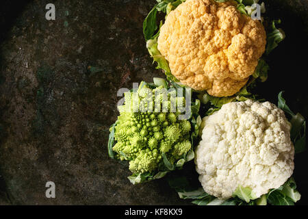 Choix de fruits colorés biologiques crus choux-fleurs et choux romanesco sombre sur fond de texture. Vue de dessus avec l'espace. concept de saine alimentation Banque D'Images