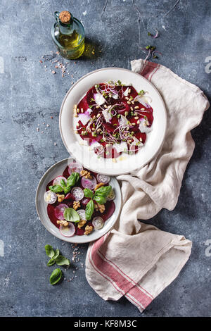 Carpaccio de betterave végétarien salade avec des radis, basilic, huile d'olive, fromage de chèvre, noix de pin, et les germes en deux sur la plaque plus serviette textile te bleu Banque D'Images