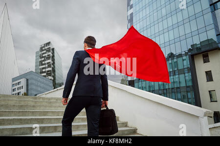 Un superhero businessman monte les escaliers d'immeubles d'affaires Banque D'Images