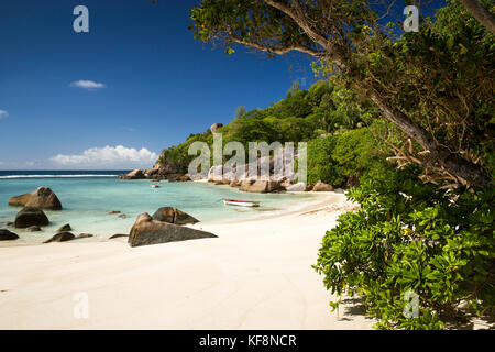 Les Seychelles, Mahe, Anse Soleil, plage, bateau amarré dans la crique rocheuse abritée Banque D'Images