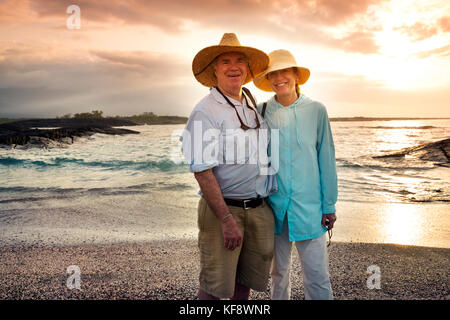 Îles Galapagos, Equateur, personnes traîner sur la plage et regarder le coucher de soleil de l'île Fernandina Banque D'Images