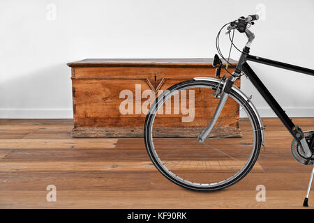 Intérieur moderne avec coffre en bois vintage et vélo en premier plan Banque D'Images