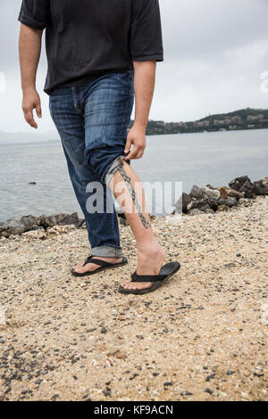 Usa, Oahu, Hawaii, le Ju-jitsu arts martiaux fighter keith chang montre une partie de son tatouage l'art à l'étang du poisson de kaneohe Banque D'Images