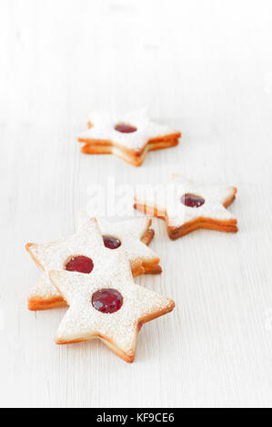 Linzer cookies traditionnels - stars avec confiture de canneberges rouges et blancs sur la table en bois. noël et nouvel an de pâtisseries. Banque D'Images