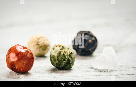 Extreme close-up view of poivre et sel sur table en bois gris. Divers grains de poivre de couleur avec l'exemplaire de l'espace. Concept de cuisson. Banque D'Images