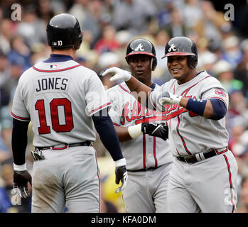 Andruw Jones des Atlanta Braves, à droite, est accueillie par ses coéquipiers Chipper Jones, à gauche, et Edgar Renteria après qu'il ait frappé un homer à trois manches du lanceur Derek Lowe lors de la cinquième manche d'un match de baseball à Los Angeles le lundi 3 avril 2006. Photo de Francis Specker Banque D'Images