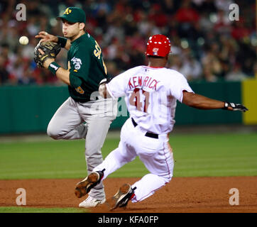 Oakland Athletics le deuxième but marco scutaro, gauche, perd la poignée sur le ballon en essayant de faire un lancer au premier but comme los angeles angels' Howard kendrick est expulsée à la deuxième base dans la cinquième manche d'un match de baseball à Anaheim, Californie le lundi 1er mai 2006. photo par francis specker Banque D'Images