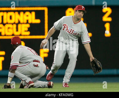Philadelphie Phillies gauche, le fieleur Pat Burrell, à droite, et court arrêt Jimmy Rollins ne peut pas atteindre un ballon de mouche frappé par Willy Aybar des Dodgers de Los Angeles qui a été marqué un single dans le troisième repas d'un match de baseball à Los Angeles jeudi, 1 juin 2006. Photo de Francis Specker Banque D'Images