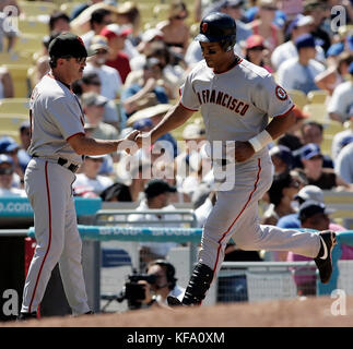 L'alou de Moises de San Francisco Giants, à droite, est félicité par le troisième entraîneur de base, Gene Glynn, après avoir fait une course à domicile au large du pichet de Los Angeles Dodgers Joe Beimel dans le septième repas d'un match de baseball à Los Angeles samedi, 8 juillet 2006. Photo de Francis Specker Banque D'Images