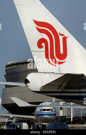 A340 garé au terminal1 avec une passerelle d'attache sur les délais d et B747-400 queue, logo, winglet et APU cône de queue Banque D'Images