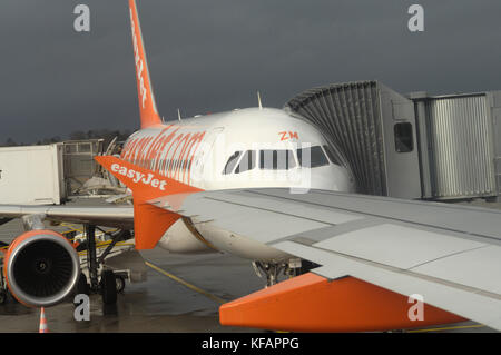 Au début et à la fin de l'ailette d'un easyJet Airbus A319-100 et un autre A319-100 garé avec une passerelle d'attaché au terminal Banque D'Images