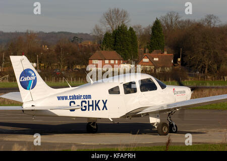 Un Piper PA-28-161 Cherokee Cabair guerrier 2 roulait avec un moteur diesel Thielert Centurion et d'arbres et maisons derrière Banque D'Images