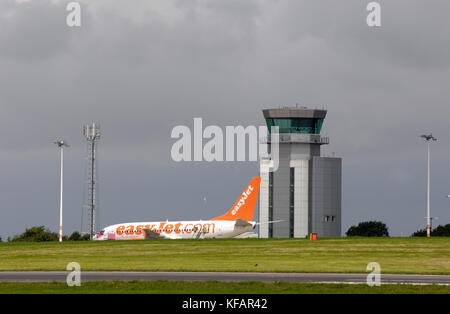 Un Boeing 737-700 d'easyJet stationné avec l'air traffic control-tour derrière Banque D'Images