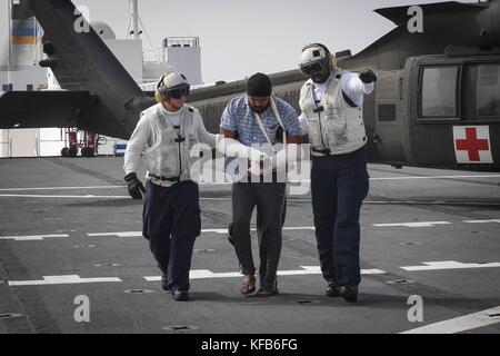 Des marins de l'US Navy à bord du navire-hôpital de classe Mercy USNS Comfort escortent un patient portoricain blessé lors d'une évacuation médicale à la suite de l'ouragan Maria le 19 octobre 2017 dans la mer des Caraïbes. (Photo Ernest R. Scott via Planetpix) Banque D'Images