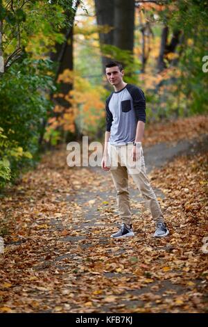 Teenage boy posant pour un portrait à l'extérieur tandis que l'occasion d'une randonnée dans une forêt en automne Banque D'Images