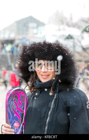 Usa, Colorado, Aspen, une femme se tient maintenant ses skis à la base d'aspen mountain, aspen ski resort, Ajax Banque D'Images