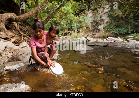 Philippines, Palawan, barangay région, jeune mère batak et lenilyn diovina fille laver la vaisselle dans le flux en kalakwasan village Banque D'Images