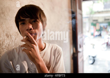 Vietnam, Hanoi, restaurant pho gia truyen, également connu sous le nom de 49 bat dan, portrait d'un jeune cuisinier ayant une cigarette et prendre une pause Banque D'Images