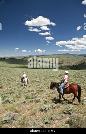 USA, Wyoming, du cantonnement, un cowboy et cowgirl ride à travers un paysage sans fin, Abara Ranch Banque D'Images
