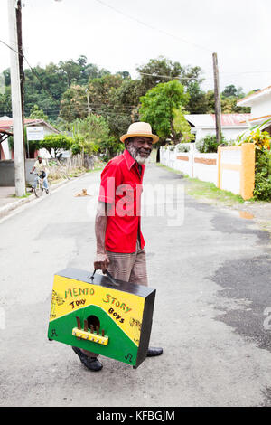 La JAMAÏQUE, Port Antonio. Derrick 'Johnny' Henry du Mento band, le Jolly Boys, transportant les marumba fort. Banque D'Images