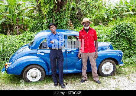 La JAMAÏQUE, Port Antonio. Joseph 'Poudre' Bennett et Derrick 'Johnny' Henry du Mento band, le Jolly Boys standing in front of a vintage voiture bleue. Banque D'Images