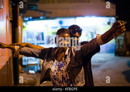 La JAMAÏQUE, Port Antonio. Un couple danse et qui pose pour un portrait dans le centre-ville de nuit. Banque D'Images