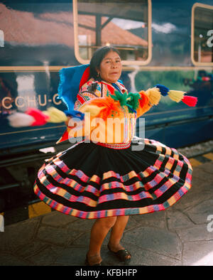 Pérou, Cusco, Amérique du Sud, Amérique latine, mature femme en costume traditionnel l'exécution devant le train Hiram Bingham. Le train circule à partir de Banque D'Images