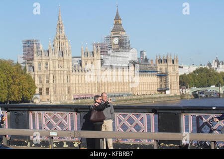 Londres, Royaume-Uni. 27 oct, 2017. un couple de poser pour vos autoportraits n lambeth bridge avec le palais de Westminster à l'arrière-plan sur glorieux matin ensoleillé crédit : amer ghazzal/Alamy live news Banque D'Images