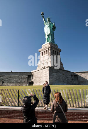 Usa, new york, une femme qui a son photo prise en face de la statue de la liberté Banque D'Images