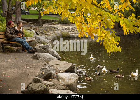 Usa (Oregon), Ashland, un couple s'asseoir et regarder les canards nager dans la rivière lithia lithia park Banque D'Images