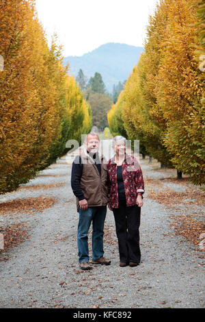 USA, Ohio, Medford, Cal et Judy Schmidt figurent parmi les arbres sur leur ferme, Schmidt Family Vineyards est situé dans la belle vallée de Applegate Banque D'Images