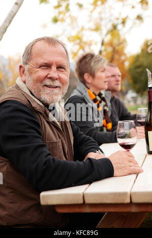 USA, Ohio, Medford, Cal Schmidt bénéficie d''un verre de vin sur sa ferme avec des amis, Schmidt Family Vineyards est situé dans la belle vallée Applegate Banque D'Images