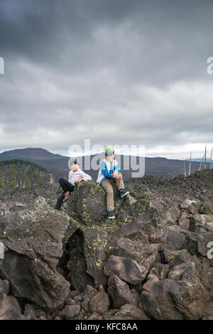 Usa, Oregon, Oregon Cascades, deux garçons jouer autour de la roche au dee wright observatoire dans le milieu d'une ancienne coulée en haut de l'mcke Banque D'Images