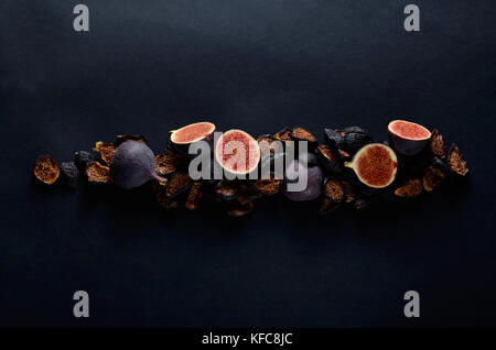 Close-up Photo de fruits frais et secs Figues Bleu profond sur fond sombre. Banque D'Images