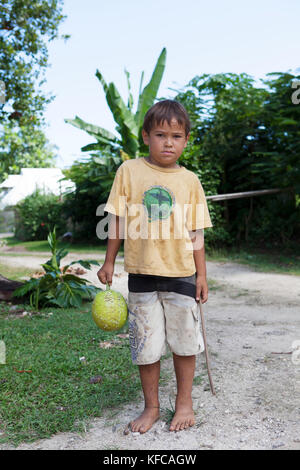 Moorea, Polynésie française. Dushan tenant un fruit à pain. Banque D'Images