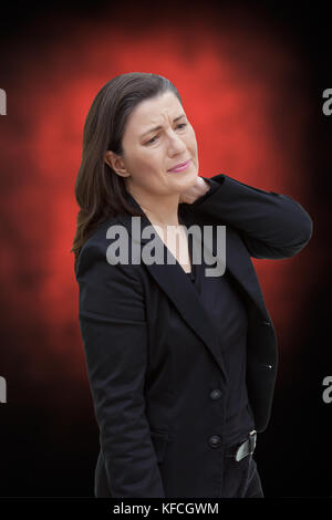 Femme d'âge moyen avec la fibromyalgie syndrome de la douleur chronique souffrant d'un oiseau, sur fond rouge et noir Banque D'Images