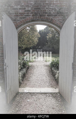 Vue par la porte aux couleurs sourdes, jardin - photo Banque D'Images