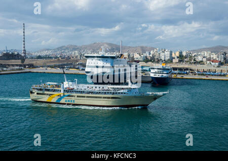 Port du Pirée, à Athènes. La Grèce. Une vue sur l'eau vers les quais de l'autre côté du port. Un navire entre dans le port. C'est un temps couvert lumineux. Banque D'Images