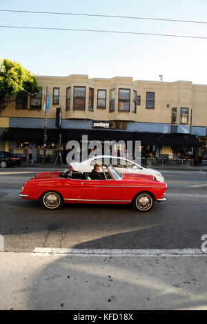 États-unis, Californie, San Francisco, un homme conduit une vieille voiture classique vers le bas dans l'avenue Columbus North beach Banque D'Images