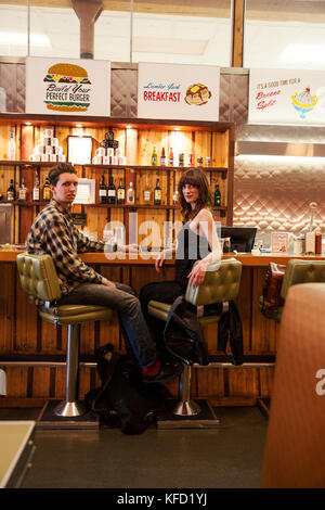 Canada, Vancouver (Colombie-Britannique), un couple local dîner au comptoir, enregistrer sur les viandes restaurant situé sur la rue Hastings ouest Banque D'Images