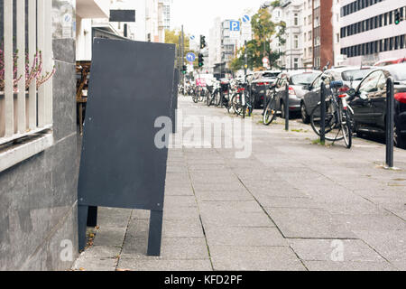 Tableau blanc sur la rue en face d'un restaurant et café place Banque D'Images