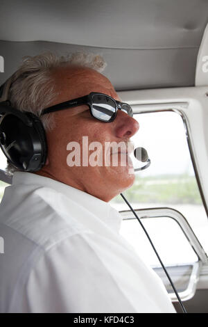 EXUMA, Bahamas. Un pilote et son avion. Il prend les passagers en provenance de Nassau à l'Exuma Islands. Banque D'Images